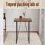 Une table de salle à manger rectangulaire rétro minimaliste avec un dessus spécialement texturé et des pieds en métal noir.