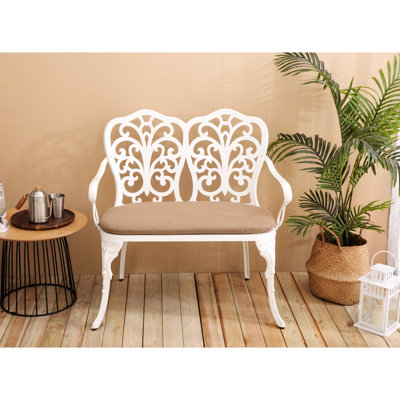 Banc ergonomique en fonte d'aluminium avec détails floraux roses et coussin blanc pour les jardins extérieurs, les patios et les pelouses