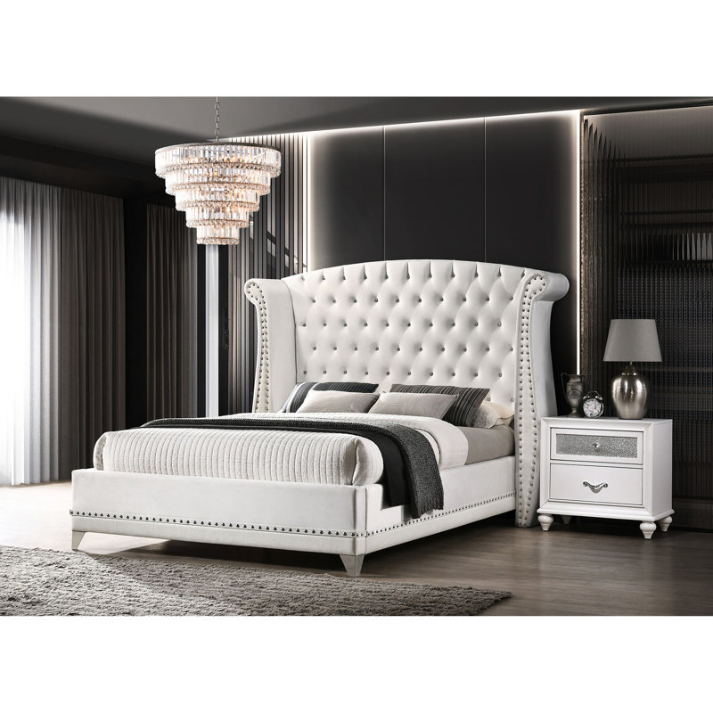 Lit à oreilles tapissier très grand en velours blanc avec tête de lit dramatique et détails pour la chambre à coucher avec revêtement, tête de lit haute, garniture cloutée