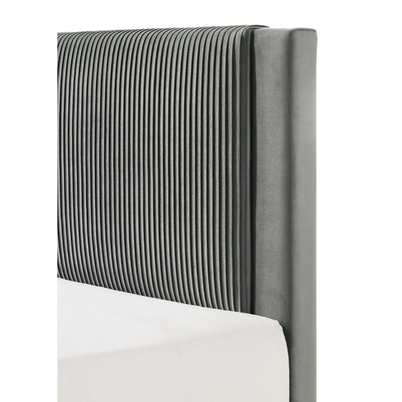 Grand lit contemporain gris avec tête de lit tapissier nervurée et structure à profil bas pour une chambre à coucher avec texture sereine