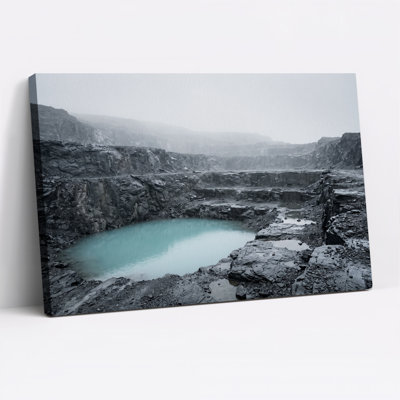 Tableau sur toile représentant un lac turquoise au milieu d'un terrain rocheux sombre