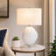 Lampe de table blanche texturée de 68 cm de hauteur avec base en cristal transparent et abat-jour ovale en lin blanc.