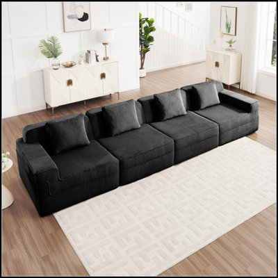 Canapé d'angle modulaire quatre places Cloud sans ossature, avec assises profondes et revêtement en velours côtelé pour une détente optimale.