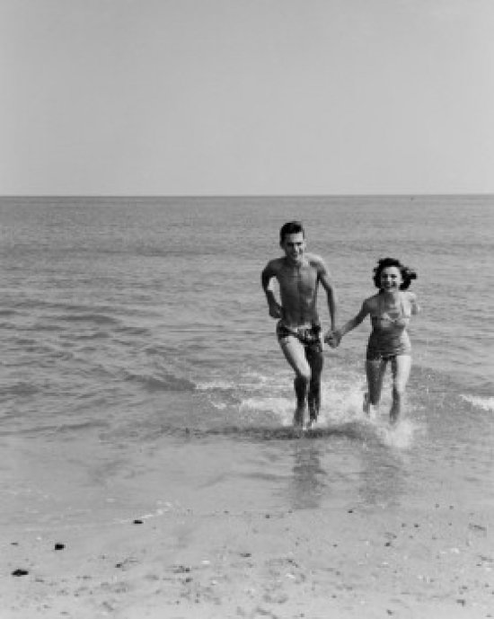 Heureux jeune couple sur la plage, tenant une affiche (24 x 36)
