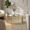 Table basse ronde moderne avec plateau en verre trempé et structure géométrique en métal doré, avec tablette de rangement inférieure