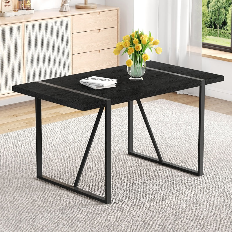 Une table de salle à manger rectangulaire rétro minimaliste de 55 pouces avec un plateau texturé noir et des pieds rectangulaires en métal noir incrustés. Plateau de table minimaliste en panneau de fibres à densité moyenne.
