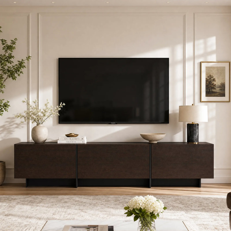 Meuble télé discret de 182 cm de large pour téléviseurs jusqu'à 224 cm, avec 3 placards rabattables et un socle surélevé.
