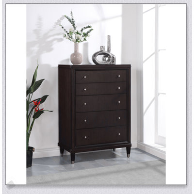 Commode brune à 5 tiroirs avec un design élégant et beaucoup de rangement, parfaite pour les chambres à coucher modernes.