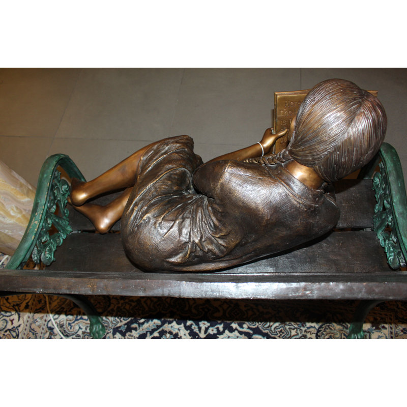 Girl laying on a bench reading a book Bronze Statue -  Size: 27"L x 39"W x 32"H