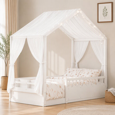 Lit Montessori au sol avec baldaquin en bois, barrières de sécurité, tablette intégrée et guirlande lumineuse.