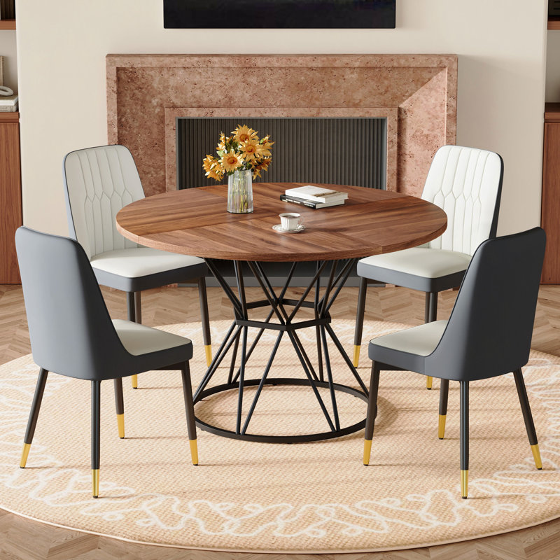 Ensemble de table et de chaises. Une table de salle à manger circulaire en panneau de fibres à densité moyenne de 47,3 po de diamètre, avec des supports en forme de sablier. Elle est assortie de 4 chaises en polyuréthane.