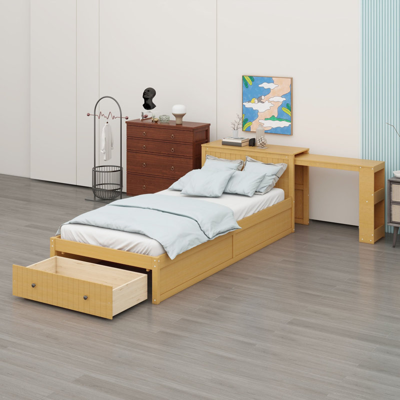 Lit plateforme avec bureau intégré et rangement, offrant une grande tablette en tête de lit et des tiroirs au pied du lit.