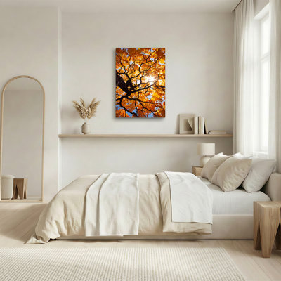 Toile orange, feuilles et branches contre ciel bleu