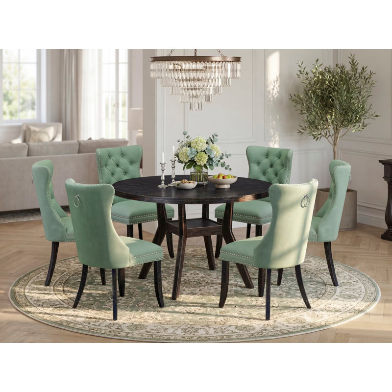 Cet ensemble de 7 pièces comprend une table ronde de 48 po avec piédestal et 6 chaises rembourrées en tissu de polyester vert saule, noir sablé