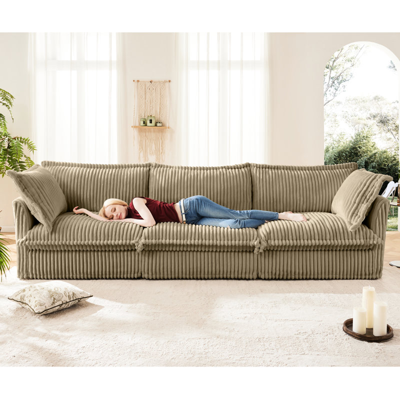Luxueux canapé trois places - Velours côtelé camel avec assise profonde et coussins pour un confort optimal, ambiance douce et chaleureuse.