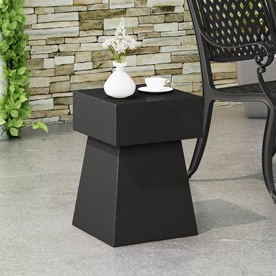 Table d'appoint moderne en béton léger avec forme de piédestal, parfaite pour les intérieurs contemporains et peu encombrante.