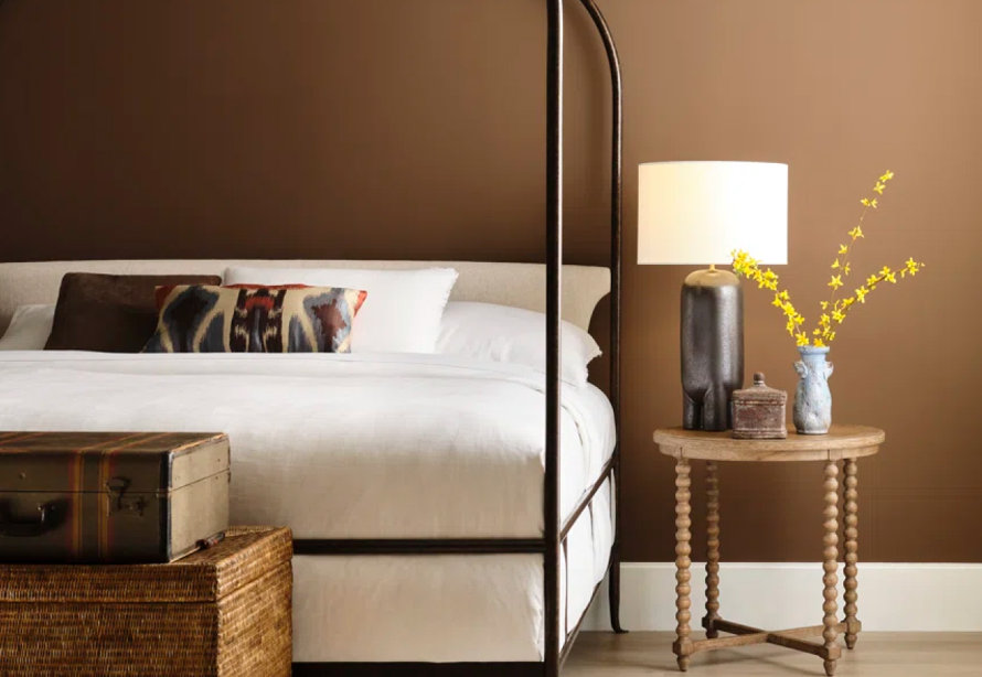 Bedroom with bed, trunk, and side table.