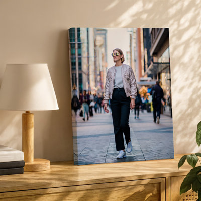 Canvas A Stylish Woman Walks Confidently Down A Bustling City Street Wall Art Wearing A Chic Embroidered Bomber Jacket Over A Light Canvas Wall Art