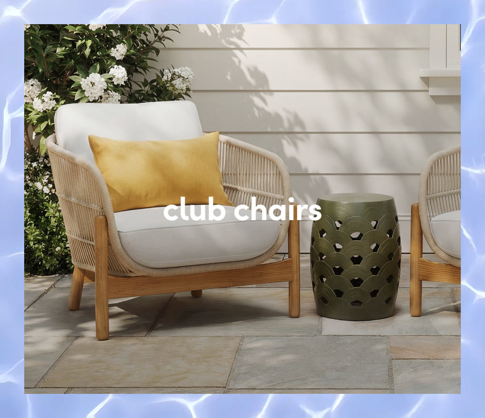 A woven outdoor club chair with white cushions and a yellow lumbar pillow next to a green ceramic garden stool.