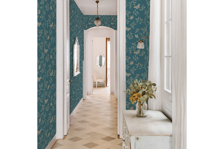 Hallway with blue floral wallpaper and beige tile floors.