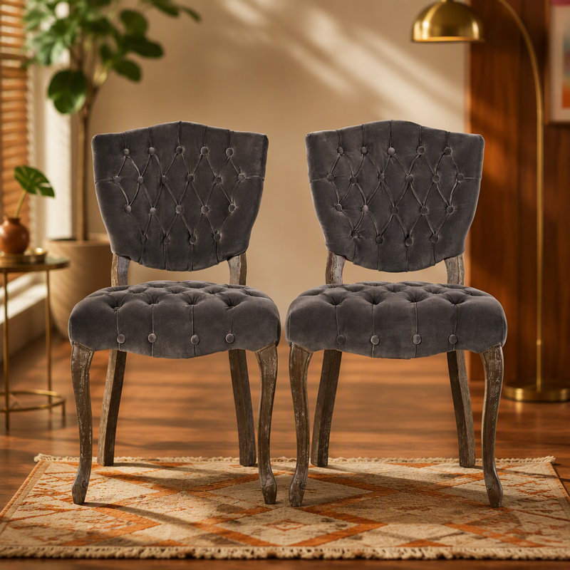 Ensemble de deux chaises capitonnées d'inspiration européenne avec pieds sculptés à la main et revêtement capitonné pour des solutions d'assise polyvalentes.