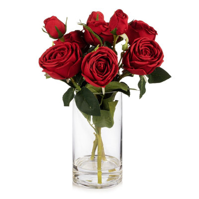 Fleurs artificielles en soie rose dans un vase en verre transparent avec de l'eau artificielle