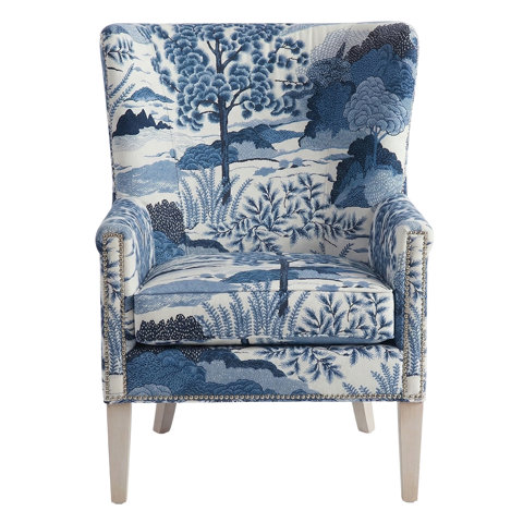 Upholstered armchair with blue and white pastoral print.