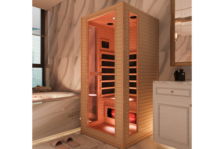 1-person wooden infrared sauna tucked between a bathtub and a bathroom vanity.
