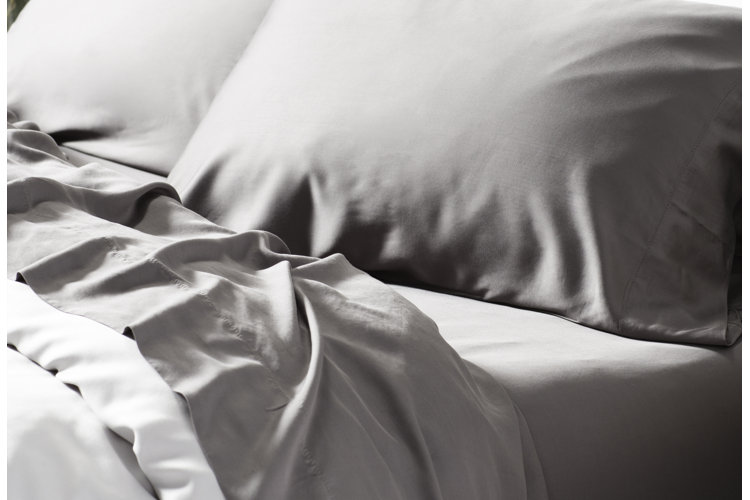 bed with gray sheets and pillowcases