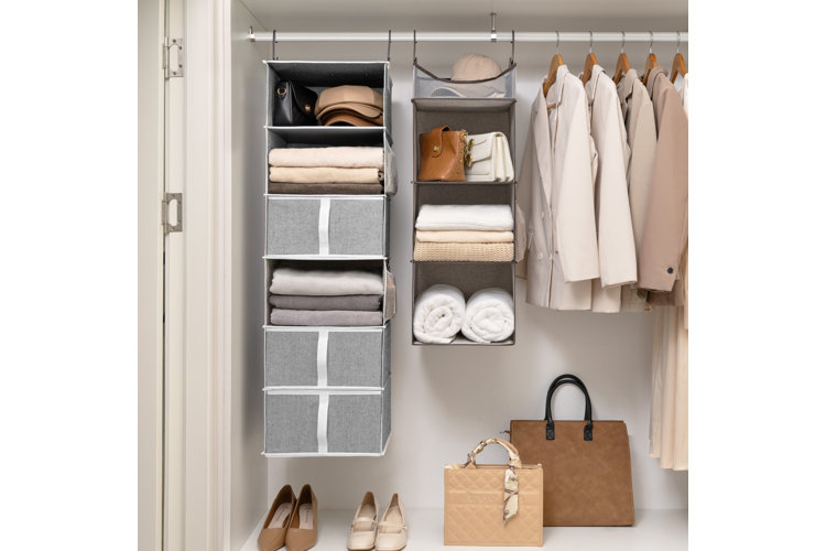 coat closet with hanging organizers, cedar coat hangers, and decorative storage bins