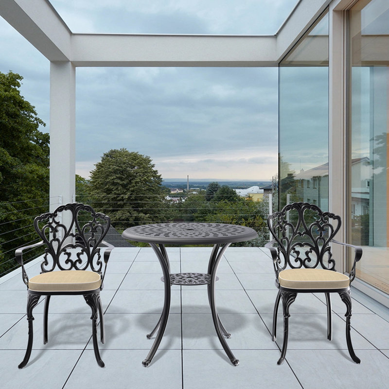 Table et chaises de patio noires en fonte d'aluminium avec coussins en tissu de couleur rouille