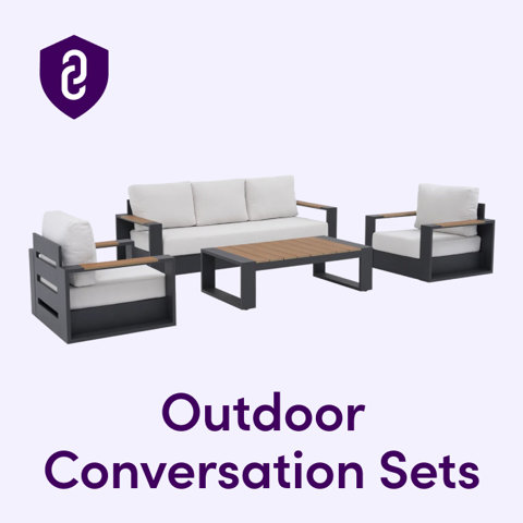 Modern outdoor conversation set with gray metal frames, white cushions, and wood accents