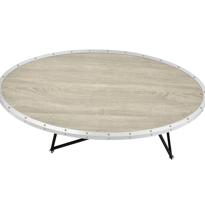 Table basse ovale de style industriel avec finition en chêne gris patiné et supports en métal noir pour une grande surface
