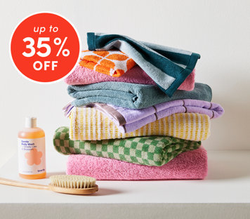 Bathroom essentials up to 35% off featuring colorful stacked towels with body wash and brush
