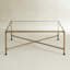 Table basse Kyea moderne avec dessus en verre et structure en laiton antique