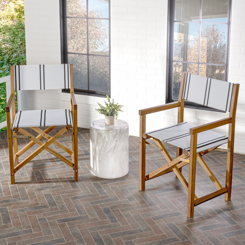 Chaises de réalisateur pliantes en bois d'acacia Cukor Coastal, siège en tissu de polyester rayé noir / blanc et structure en teck brun pour patio, terrasse et balcon