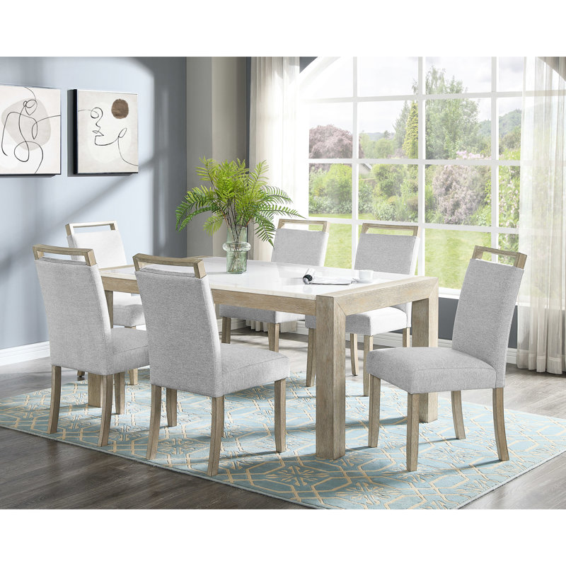 Ensemble de salle à manger moderne de 7 pièces comprenant une table rectangulaire en marbre blanc et des chaises élégantes et finement rembourrées.