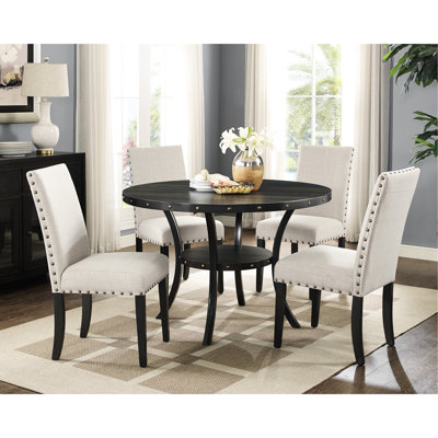 Ensemble de salle à manger en bois. 5 pièces avec table ronde et chaises en tissu beige avec clous décoratifs. Plateau en bois au fini grain de café, pattes en métal. Chaises recouvertes de lin et de coton, cloutées de tête en laiton. Structure en lin.