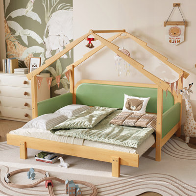 Lit en bois dans une cabane dans les arbres avec rails à coussin moelleux