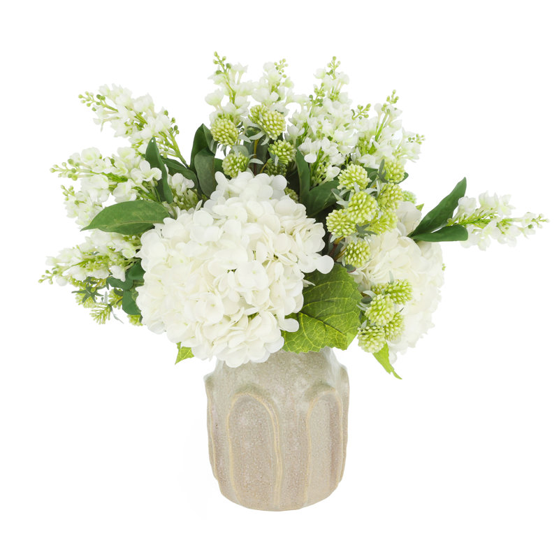 Hortensias et lilas disposés dans un vase en céramique