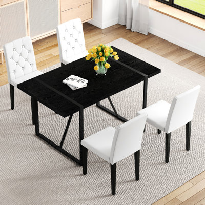 Ensemble de table de salle à manger en bois aggloméré noir imitation grain de bois. Table de salle à manger rectangulaire rétro minimaliste avec plateau texturé noir. Ensemble de 4 chaises de salle à manger en polyuréthane blanc: dossier à boucle ergonomique. Une touche tendance.