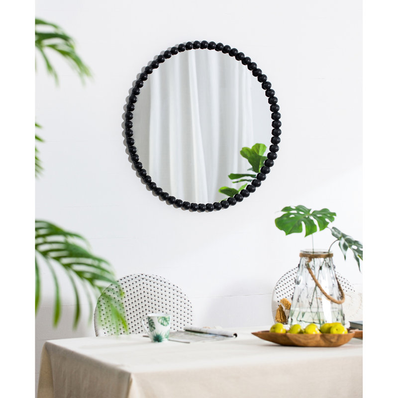 Le miroir 32 po à cadre perlé en métal ajoute une touche de luxe au mur du salon