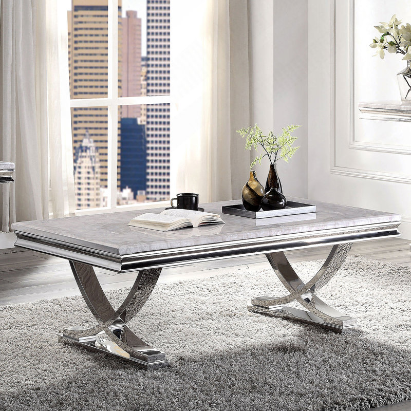 Table basse moderne de style glamour avec plateau en faux marbre et base piédestal chromée, parfaite pour les espaces de vie luxueux.