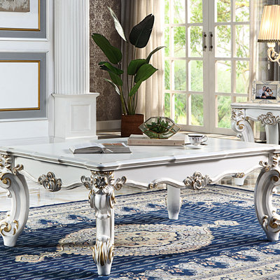 Élégante table basse en perle antique avec pieds à volutes complexes - s'adapte à différents intérieurs avec volutes de pieds ornementales