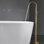 Robinet de baignoire autoportant avec douchette à main en or - fixation au sol, forme incurvée, poignée de douche amovible en céramique brossée, aspect classique,
