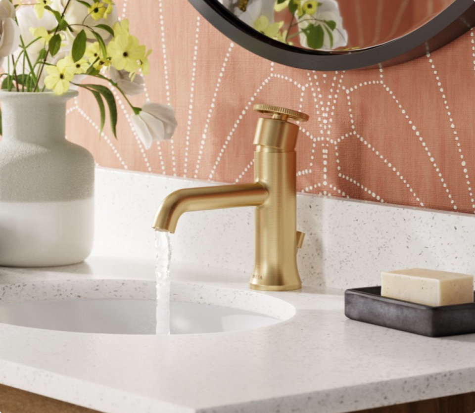 Gold faucet with water running into sink.