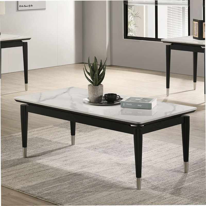 Table basse de style contemporain avec plateau en pierre frittée et pieds en flèches argentées avec finition noire et blanche