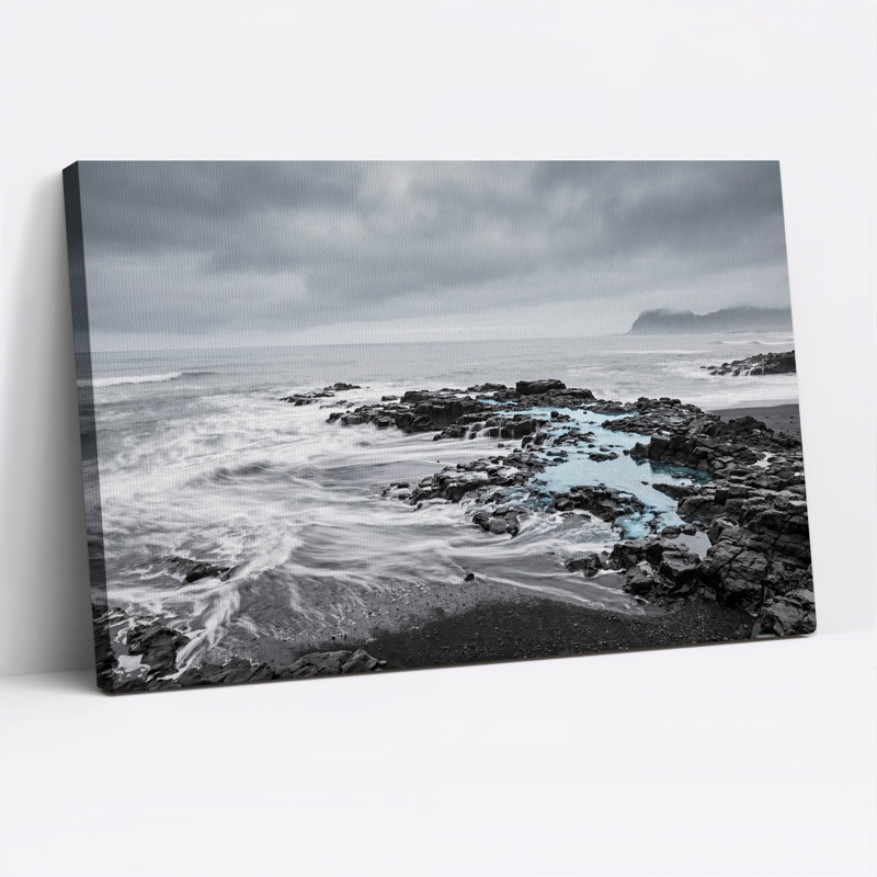 Tableau sur toile représentant un rivage rocheux en noir et blanc avec une eau bleue, H 18 po x l 24 po