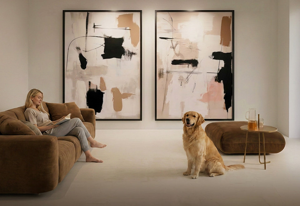 Woman reading on a brown sofa with a golden retriever in a modern living room featuring large abstract wall art, with the text Find your perfect fit for any space.