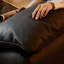 Causeuse-coussin modulable noire en cuir véritable